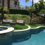 Pool and Spa with Artificial Grass white coping and stack stone on raised bond beam