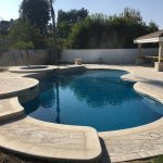 Pool and spa with different levels dark blue water and gazebo